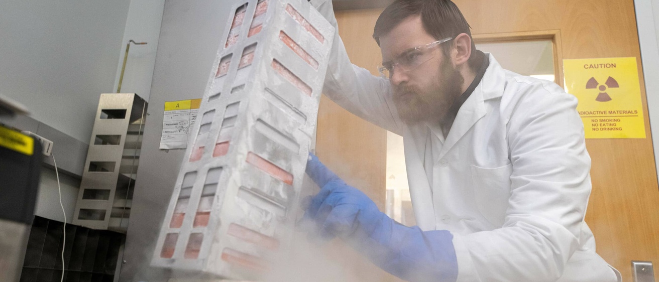 A student wearing PPE works in a lab