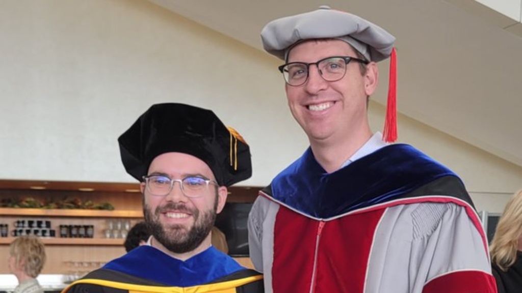 Michael Schrodt and James Ankrum wearing academic gowns